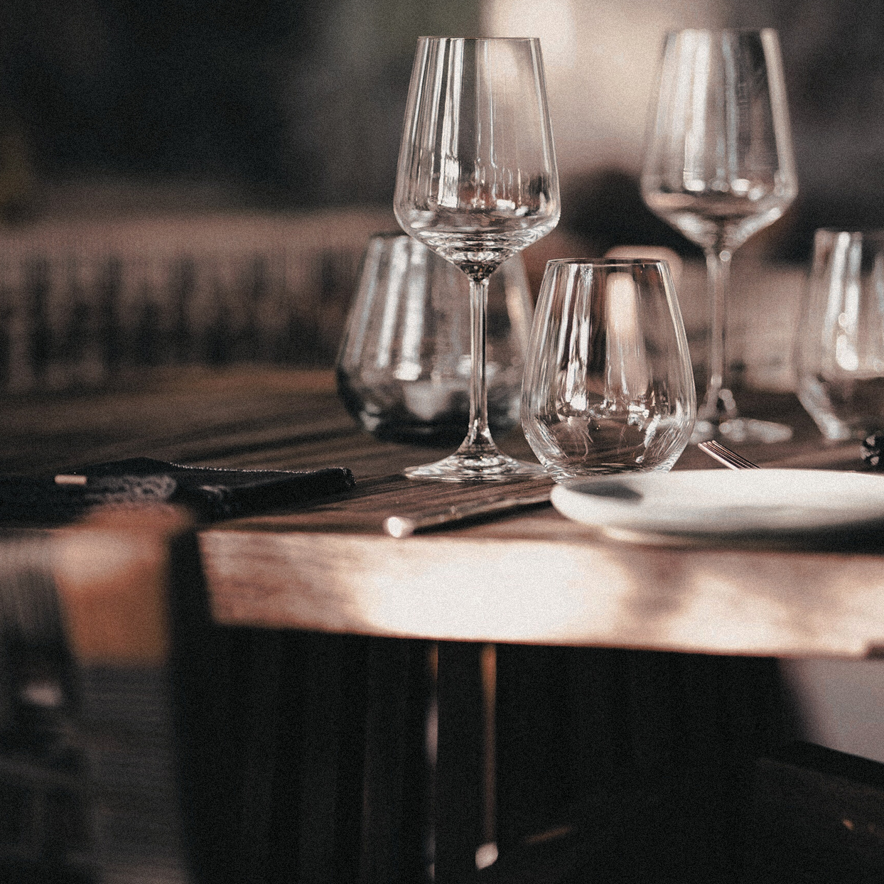 Table set with wine glasses and elegant dining setup, representing Creative Hospitality’s hospitality management solutions for refined guest experiences.